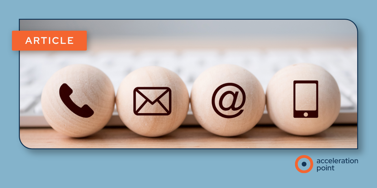 Four wooden spheres etched with phone, email, at-symbol, and mobile icons sit in a row near a keyboard, representing the multiple communication channels involved in a coordinated KOL engagement strategy.